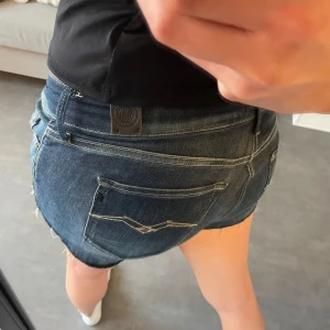 Lågmidjade jeansshorts - Fina vintage lågmidjade jeansshorts från replay använda några gånger med brodering på fickorna