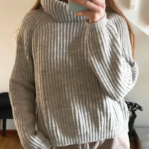 Grå ribbad polotröja stickad - Supermysig grå stickad polotröja med bred ribbad struktur och hög krage. Tröjan har en loose passform och långa ärmar, perfekt för svala sommarkvällar❤️