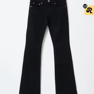 Svarta bootcut jeans från gina tricot - Säljer ett par svarta jeans från gina tricot med bootcut-modell och låga i midjan. Jeansen har klassisk femficksdesign, knapp och dragkedja framtill samt snyggt utsvängda ben. Perfekta för dig som gillar en tidlös och clean look.