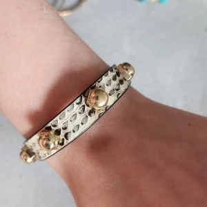 Läderarmband. - Läderarmband med guldnitar. 