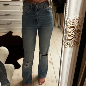 Blå raka jeans från Pull&Bear - Snygga blå jeans från Pull&Bear med raka ben och hög midja. Jeansen har slitna detaljer vid knäna och är i storlek 32!😊