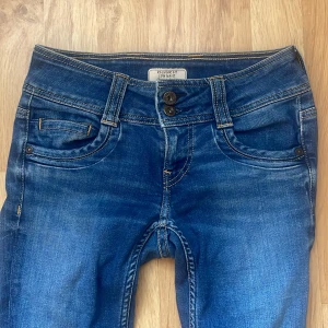 Blåa lågmidjade jeans från Pepe Jeans London - Snygga blå jeans från Pepe Jeans London med regular fit, straight fit och låg midja. Den är i storlek xs skulle jag säga, skriv för mått.🙌🏻 Jeansen har raka ben och är tillverkade i slitstark denim av bomull.💕