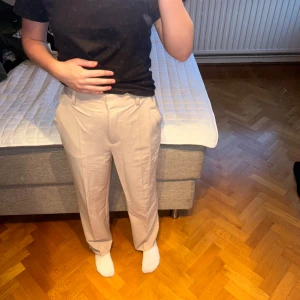 Beige kostymbyxor med raka ben - Snygga beige kostymbyxor med raka ben och hög midja. Använa en gång. 