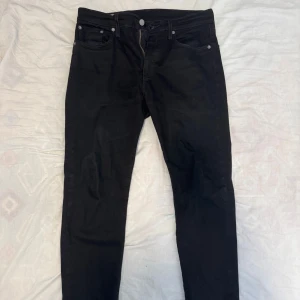 Svarta Levi's 511 jeans - Säljer ett par svarta Levi's 511 jeans med klassisk femficksdesign och smal passform. Jeansen har Levi's ikoniska röda etikett på bakfickan och svart läderpatch i midjan. Tillverkade i stretchig bomullsdenim för extra komfort.