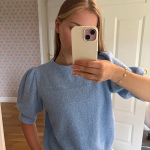 Ljusblå stickad tröja Vero Moda - Superfin ljusblå stickad tröja från Vero Moda med puffiga korta ärmar och rund halsringning. Mjuk och skön, perfekt för vår och sommar. Enkel att styla till både jeans och kjol för en chill look.