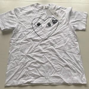Vit Comme des Garçons Play t-shirt - Säljer en vit t-shirt från Comme des Garçons Play i storlek S. Skick: 10/10. Passar någon som är mellan 173-177 cm lång! Priset går att diskutera! Hör av dig vid frågor eller intresse!