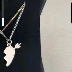  Maria Nilsdotter halsband  - (Maria Nilsdotter liknande halsband)Snyggt halsband med ett trasigt hjärta och pil i silverfärg. Hängsmycket har en cool, kantig design och kedjan är tunn och stilren. Perfekt accessoar för dig som gillar unika smycken med attityd.