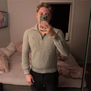 Grå half zip tröja Polo Ralph Lauren - Säljer en stilren grå tröja från Polo Ralph Lauren i mjuk pima bomull. Tröjan har half zip-dragkedja, ribbade muddar och diskret logga på bröstet. Perfekt för lager-på-lager och funkar året runt. Sitter mer som S och har lagat ett hål på armen
