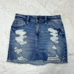 Hollister jeanskjol med hål  - Superfin jeanskjol med hål från hollister, storlek w23 enligt lapp men jag som har w26-w27 kan ha den. Skulle mer säga att den sitter som en 25-liten 26.. Midjemått:34-35 (obs tänk på att denna kjol sitter högre upp när du går efter midjemått) köp sker via köp nu, jag postar inom 24h. Kvar tills markerad såld 