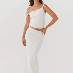 Vitt sett  - Vitt sett som är köpt separat. Elegant vit oneshoulder top med en tight passform och skruvade band. Långkjol i bekvämt material. Inte genomskinligt. Köpt från peppermayo för 570kr stycket. Fråga för egna bilder. 