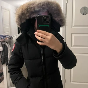 Chelsea Parka canada goose  - Säljer en Chelsea Parka goose jacka som e  stor, fluffig pälsfodrad huva. Använd i en vinter, jättebra skick. Det går att justera den vid midjan✨✨Jätte skön och varm.Storlek XS men passar S! Inga skador.