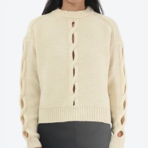 Beige stickad tröja med flätad detalj - Säljer en snygg beige stickad tröja med unik flätad detalj längs ärmarna och framsidan. Tröjan har en ribbad kant vid halsen och ärmsluten, vilket ger en stilren look. Perfekt för kyligare dagar! Fått lite smink på men skickar på(skickar gärna bilder på)