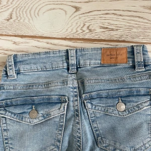 Ljusblå jeans från Perfect Jeans - Snygga ljusblå jeans från Perfect Jeans med klassisk femficksdesign och knappgylf. De har en straight passform och är perfekta för en avslappnad stil. Märkeslapp i läderimitation baktill ger en extra touch.