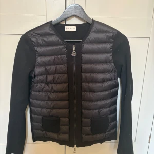 Svart jacka från Moncler - Snygg svart jacka/cardigan från Moncler med quiltad design och dragkedja framtill. Jackan har långa ärmar och två fickor❤️nypris idag ca 10000 kr