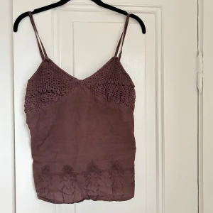 Brun linne med spetsdetaljer - Säljer ett brunt linne köpt i Spanien med smala axelband och vacker spetsdetalj nertill 🤎🤎🤎