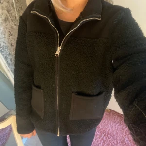 Svart teddyjacka med dragkedja - Mysig svart teddyjacka med dragkedja och stora fickor framtill. Perfekt nu till våren! Fråga gärna om fler bilder 🥰