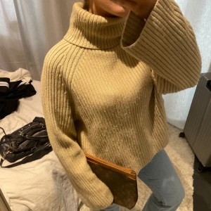 Beige stickad polotröja - Säljer en mysig beige stickad polotröja med ribbad struktur. Tröjan har långa ärmar och en hög polokrage som håller dig varm under kyliga dagar🤎🤎