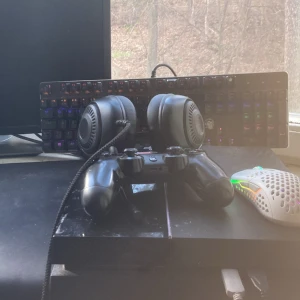 Svart gamingtangentbord med hörlurar och mus - Säljer ett komplett gamingkit med ett svart tangentbord med RGB-belysning, ett par svarta hörlurar och en vit gamingmus med perforerad design. Perfekt för den som vill uppgradera sin spelupplevelse. Kontakta för mer info!