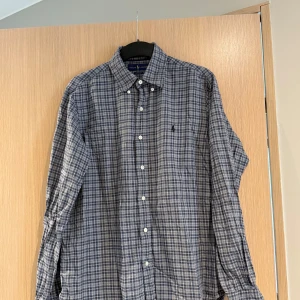 Blårutig skjorta från Ralph Lauren - Säljer en klassisk blårutig skjorta från Ralph Lauren. Måttet är ca 70cm lång, bred 52cm. Storleken är M och skicket är bra om ni stryker den kommer den se som ny ut🤩 Nypris cirka 1600kr