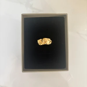 Guldfärgad ring med organisk form - Säljer en unik guldfärgad ring med en organisk, skulpterad design. Ringen har en chunky känsla och passar perfekt som statement piece. Perfekt för dig som gillar trendiga accessoarer med lite edge. 