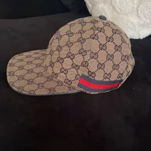 Gucci keps - En Gucci keps som är bara för liten på mig annars så skick 9/10 allt e perfekt inget fel på den passar perfekt, Bara inte min still längre!! Kan mötas upp i Göteborg också 