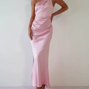 Ljusrosa långklänning med oneshoulder - Säljer en ljusrosa långklänning med oneshoulder-design med glansigt satinliknande material. Perfekt för balen💗💗🥂 helt ny med lapparna kvar