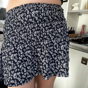 Mörkblå blommig kjol från Gina Tricot - Supersöt mörkblå kjol från Gina Tricot med vitt blommönster. Kjolen har smock i midjan och är kort med en lätt utsvängd form. Passar perfekt till sommaren, använt endast några gånger! Säljer även matchande topp i en annan ad ❤️