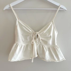 Vit topp med knyt - Så söt kort topp från Nelly, knappt använd🤍🌞