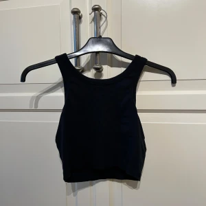 Svart ribbad linne från lager 157 - Säljer en svart ribbad linnetopp från lager 157 i storlek XS. Toppen har en croppad passform och breda axelband. 
