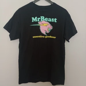 Svart MrBeast t-shirt - Svart t-shirt från MrBeast med färgglatt tryck framtill. Motiv med MrBeast-loggan och texten 'executive producer' i gult. Perfekt för dig som gillar YouTube