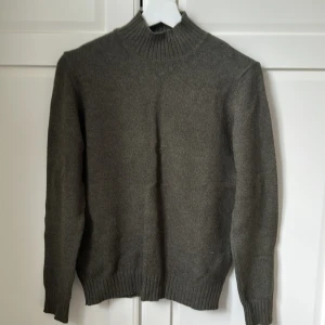 Mörkgrön stickad polotröja från VILA - Mysig mörkgrön stickad polotröja från VILA med ribbade muddar och hög krage. Fin kvalitet på tröjan. Aldrig använd ! 🙏🏻 (priset är alltid diskuterbart)