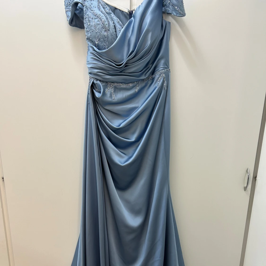 Ljusblå långklänning med drapering och pärldetaljer