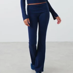 Mörkblå bootcut byxor med låg midja från Gina - Snygga mörkblå byxor med bootcut passform och låg midja. Byxorna har en slät framsida utan synliga detaljer och är perfekta för en trendig och avslappnad look.