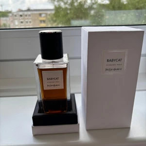 Yves Saint Laurent Babycat Eau de Parfum - Exklusiv parfym från Yves Saint Laurent med namnet Babycat. Flaskan är rektangulär i genomskinligt glas med svart lock och etikett. Doften har noter av läder och vanilj. Kommer i en stilren vit kartong med silverdetaljer.