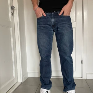 Blå shyssta jeans från Acne studios - Klassiska blå Acne jeans med rak passform och normal midja. Jeansen har fem fickor, knappgylf och tydliga sömmar. Perfekta för en avslappnad stil och passar till det mesta. W31 W32