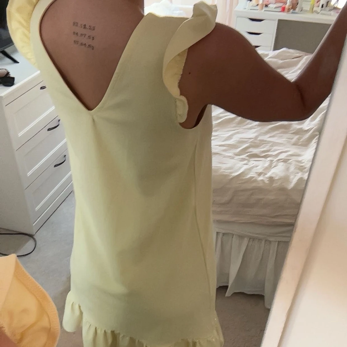 Ljusgul klänning med volangdetaljer - 1