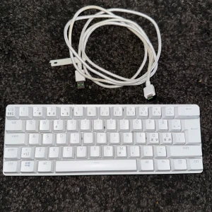 Razer Huntsman Mini – kompakt gamingtangentbord i Mercury - Razer Huntsman Mini – Mercury Kompakt 60% gamingtangentbord. Fungerar som det ska men är inte i nyskick – lite smutsigt och ett stöd på baksidan saknas, så det står platt. Original USB-C kabel medföljer. Perfekt för dig som vill ha ett stilrent och snabbt tangentbord till ett bra pris. Pris kan diskuteras!