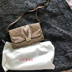 Beige axelväska från  Guess - Säljer en beige axelväska från Guess. Väskan har justerbar axelrem och stängs med ett guldfärgat spänne. Aldrig använt. Den kommer med själva guess påse. Priset kan såklart diskuteras. 💗💗