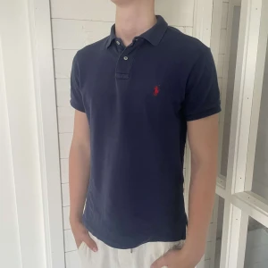 Ralph lauren pike - Säljer denna snygga marinblå Ralph lauren pike som är i mycket bra skick utan några som helst defekter och i storlek S, hör gärna av dig vid frågor.