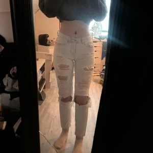 Boyfriend low waist jeans med hål - Säljer ett par ljusa Boyfriend jeans med snygga slitningar och hål på benen. Modellen är lågmidjad  och har raka ben med klassiska fem fickor och knappar framtill. Lite små för mig