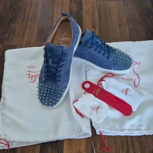 Blå Christian Louboutin sneakers med nitar - Tjena, säljer ett par ljusblåa christian louboutin med en ikoniska röda sulan. Jag säljer dem för dem var lite för små och dem har inte varit till så mycket användning för min del. Insulan är exakt 28 cm. Tyvärr följer ingen box med därav priset. Om du har fler frågor eller om du undrar något specifikt så är det bara att fråga!
