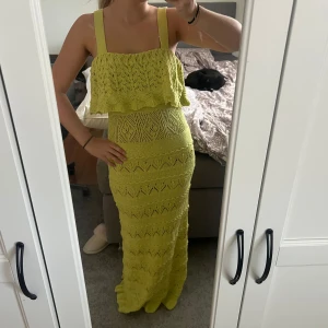Grön lång stickad klänning från Zara - Säljer en Grön lång klänning från Zara i stickad bomull. Klänningen har breda axelband, volang upptill och ett snyggt hålmönster över hela plagget. Perfekt för sommarens alla tillfällen och ger en riktigt fräsch vibe. Stolek xs
