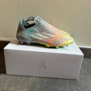 Adidas X Speedflow+ FG fotbollsskor - Adidas X Speedflow+ FG är grymma fotbollsskor i syntetmaterial med en futuristisk design i silver, gult, orange och turkost. Skorna är i st 41 1/3. De säljs inte längre och är limited edition. Nypris runt 3000 kr. Skorna är använda och man kan se defekter på framsidan och på sulan av skon, men fungerar som de ska. Lådan med kommer och priset är inte hugget i sten. Ifall du har några funderingar eller vill ha fler bilder är det bara att skicka ett meddelande🙌🙌