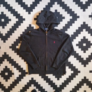 Ralph lauren zip up hoodie  - 📊 Färg: Svart   📏 Storlek: Extra small (XS)  📐 Mått: Längd - 60cm Axelbredd - 43cm  ♻️ En långärmad svart Ralph lauren zip up hoodie i storlek XS. I väldigt bra skick, inga fläckar, hål eller defekter! Perfekt nu när det börjar bli lite kyligate och hösten kommer!☺️  👕 Material: 100% Bomull  #mensfashion #style #ralphlauren #classicstyle  #fashion