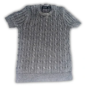 Grå stickad tröja från Ralph Lauren - Snygg grå stickad tröja från Ralph Lauren med korta ärmar och klassiskt kabelstickat mönster. Tröjan har rund halsringning och är perfekt för dig som gillar en stilren och tidlös look. Passar till både jeans och kjol. köpt för över 200 €!!