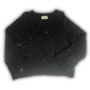 Svart glittrig stickad tröja från Zara - Svart stickad tröja från Zara med glittriga paljetter över hela ytan. Tröjan har rund halsringning och långa ärmar. Perfekt för dig som vill sticka ut med lite extra bling och ändå hålla det mysigt och bekvämt.
