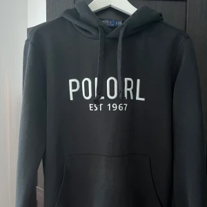 Svart hoodie Polo Ralph Lauren - Tja! Säljer en riktigt snygg Ralph Lauren hoodie i en riktigt go passform! Enda defekten är att hoodien kan bli lite nopprig som man kan se på bild 3. Detta är helt omärkbart och är nästintill osynligt. Skriv vid funderingar! Pris kan diskuteras vid snabb affär! 