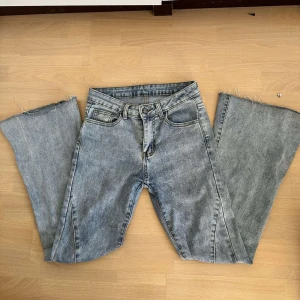 Ljusblå flared jeans - Säljer ett par ljusblå bootcut jeans med snygga råa kanter nertill, då dom är lite korta för mig som är 163. Jeansen ser ut att vara högmidjade men passar som mid/low (?) waist. Midjemått -  36 cm.  Innerbenslängd - 69 cm. Perfekt för dig som gillar en avslappnad men trendig look. Kontakta vid frågor!!