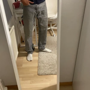 Grå Jack and Jones relaxed fit30/32 - Säljer ett par klassiska grå Levi's 501 jeans i rak modell. Jeansen har fem fickor, knappgylf och är tillverkade i slitstark bomullsdenim. Perfekt för dig som gillar en tidlös och clean look.