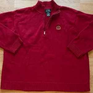Röd halvzip tröja från Ralph Lauren - vinröd vintage zip-tröja från Ralph Lauren. Står 3X men passar mer L eller XL. Mjukt bomullsmaterial, broderad logga på bröstet och RL-dragkedja. Är lite mer baggy än vanliga jumpers. Väldigt fint skick! Hör gärna av dig om du har frågor!